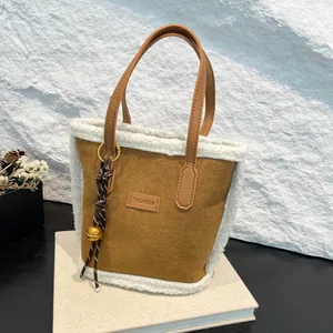 Braune Wildleder Beuteltasche mit weißem Pelzbesatz und goldenem Glockenanhänger
