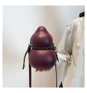 Detail of a dark burgundy gourd-shaped crossbody bag with woven rope trim and leather strap
