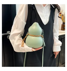 Detail of light green gourd-shaped crossbody bag with woven rope decor on model