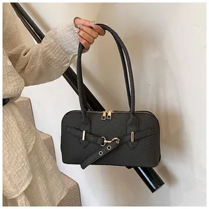Detail of black woven shoulder bag with gold hardware and stylish metal accents
