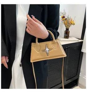 Détail d'un mini sac en cuir kaki avec boucle étoile argentée et bandoulière