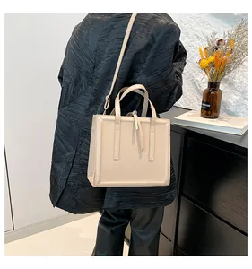 Détail d'un sac cabas blanc cassé minimaliste avec doubles poignées et coutures élégantes