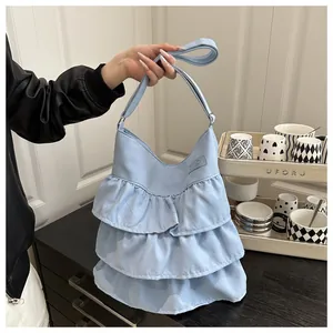 Dettaglio della borsa tote azzurra a balze con design a strati e tracolla larga