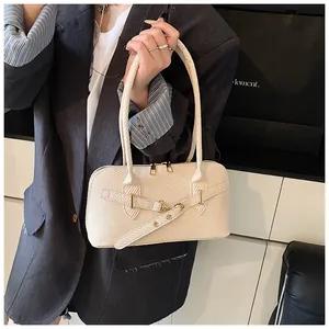 Detail of beige woven pillow bag with double zippers and gold buckles on a grey suit