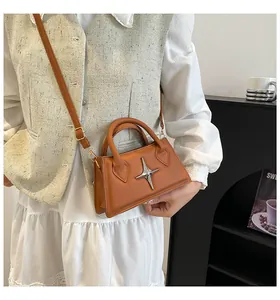Details der karamellbraunen Ledertasche mit silberner Schnalle und Schultergurt