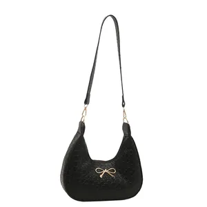 Chic black woven hobo shoulder bag with a gold bow buckle for a sweet stylish look