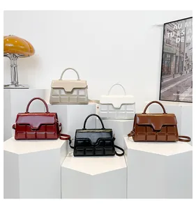 Close-up of glossy leather handbags featuring unique chocolate square embossed texture