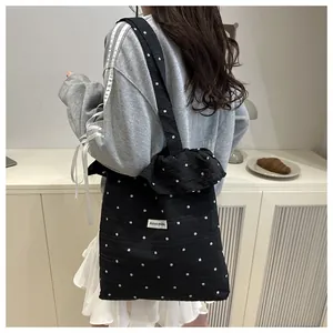 Gros plan d'un sac cabas floral noir avec des volants et des motifs de fleurs