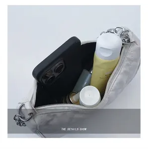 Vue macro de l'intérieur du sac matelassé blanc contenant smartphone et cosmétiques