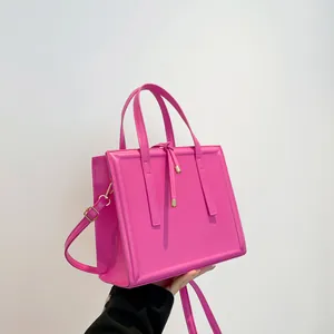 Chic bright pink tote bag with drawstring detail and elegant golden metallic hardware