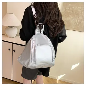 Détail du sac à dos argenté métallisé montrant la forme triangulaire et le profil latéral