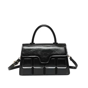 Elegante zwarte crossbodytas met vierkant reliëfpatroon en glanzende gouden hardware