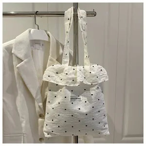 Détail du sac cabas en seersucker blanc à motif floral avec bords volantés élégants