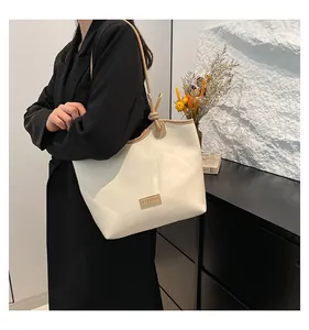 Detail of cream-white tote bag featuring contrast stitching and fashion label detail