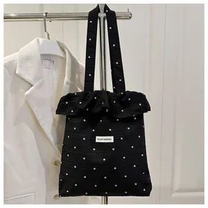 Détail du sac cabas en toile fleurie noire avec volants et étiquette Agogo Original
