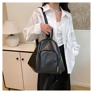 Vue latérale du sac à dos en similicuir noir élégant avec profil triangulaire porté