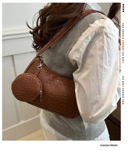 Detail einer braunen geflochtenen Schultertasche mit kleinem Beutel am Modell