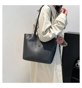 Détail du sac cabas noir avec poche frontale à bouton et surpiqûres de qualité