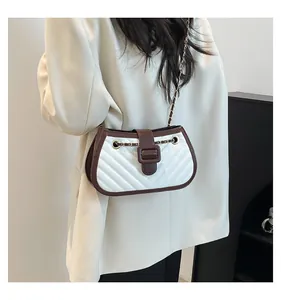 Detail of V-shaped quilting and contrast stitching on white leather crossbody bag