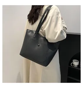 Gros plan d'un cabas noir en cuir avec poche frontale et bouton-pression élégant