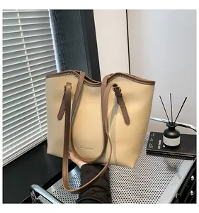 Detail of minimalist beige tote bag showing high-quality leather texture and brown strap