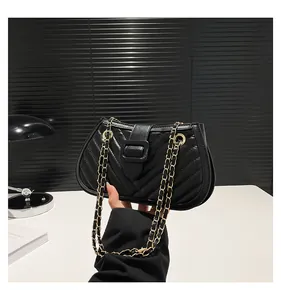 Close-up of black chevron quilted PU leather shoulder bag with gold chain strap detail