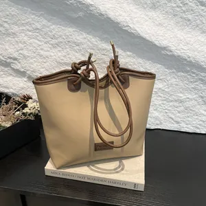 Minimalist apricot large capacity tote bag with brown knotted handles and metal accents