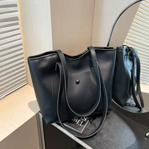 Sac cabas minimaliste en cuir noir avec poche avant à bouton-pression et fines bandoulières