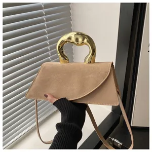 Dettaglio di borsa patchwork kaki con manico in metallo dorato irregolare e tracolla sottile