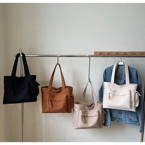 Detail view of large canvas tote bags in four colors with multiple storage pockets