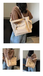 Detail view of canvas tote bag featuring a woven zipper pull and multiple functional pockets