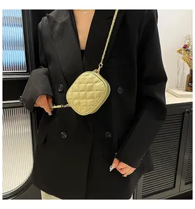 Close-up of a light green quilted mini bag featuring a stylish gold chain strap
