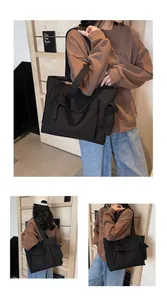 Detail of a black canvas tote bag with functional zipper pockets for daily commute