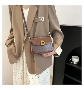 Details einer braunen Vintage-Umhängetasche mit eleganter goldener U-förmiger Schnalle