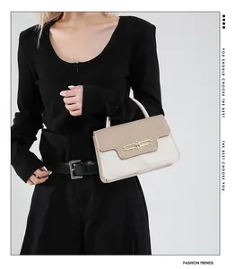 Close-up of color-block flap handbag with gold buckle and beige-brown leather details