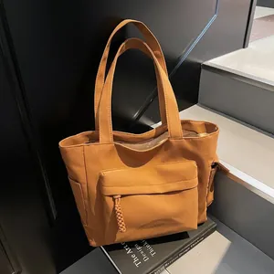 Retro canvas tote bag in brown featuring multiple pockets and woven rope zipper detail