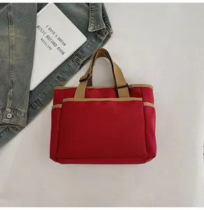 Detailansicht der roten Canvas-Tragetasche mit khaki Kontrasten und Seitentaschen