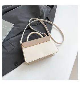 Detail of cream crossbody bag featuring straw fabric texture and thick handle
