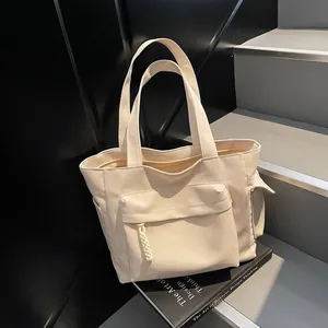 Vintage beige canvas tote bag with front flap pocket and wide straps for commuting