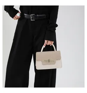 Close-up of beige woven texture and leather contrast with gold metal lock on handbag