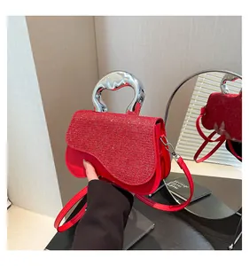 Dettaglio borsa rossa glitterata con manico curvo argento e bordo inferiore ondulato