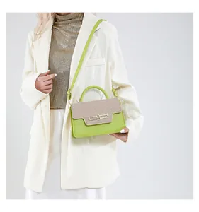 Detail of lime green and beige woven crossbody bag featuring a golden metal clasp