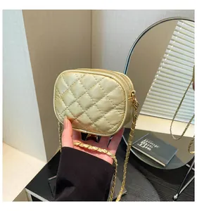 Close-up of champagne gold quilted crossbody bag with metal chain strap and zip closure