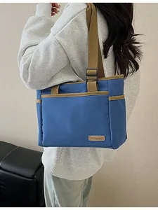 Blaue Canvas-Einkaufstasche mit verstellbarem Khaki-Gurt und Lederaufnäher an der Schulter