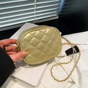 Golden quilted leather crossbody mini bag with woven chain strap in urban fashion setting