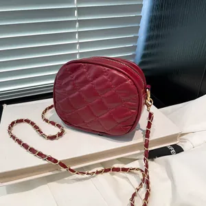Elegant burgundy quilted crossbody bag with gold chain strap on a minimalist background