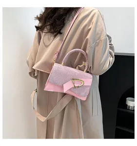 Detail of pink leather and sequin handbag with gold clasp worn with a beige trench coat