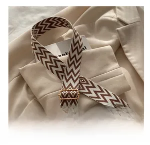 Detail of wide adjustable woven shoulder strap with brown geometric patterns for handbags