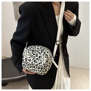 Detail of leopard print crossbody bag featuring a front pocket and adjustable strap