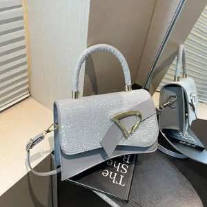 Elegant silver crossbody bag with sparkling rhinestones and golden D-buckle closure
